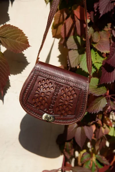Liten brun kvinnors läder väska med ett snidat mönster — Stockfoto