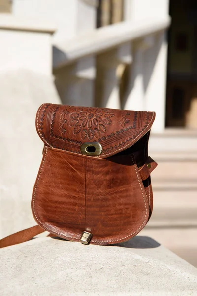 Маленькая коричневая кожаная сумка с резным узором — стоковое фото