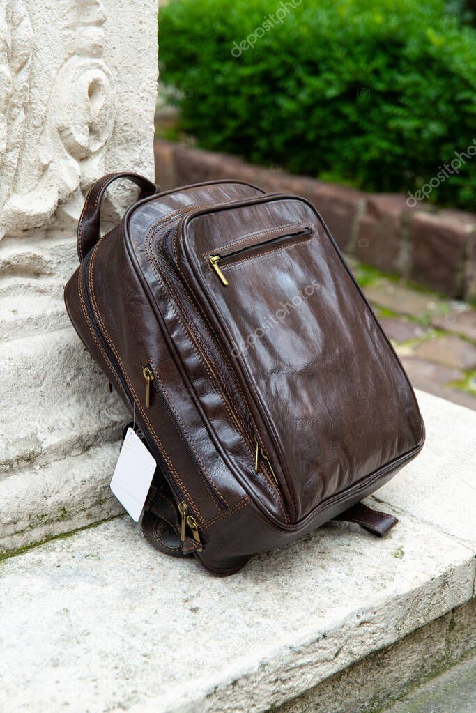 Brown leather backpack on the snone monument