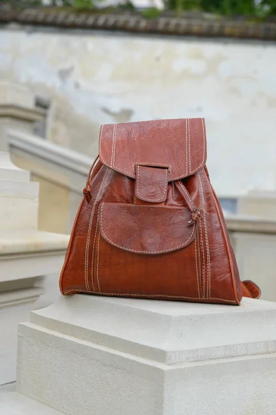 Orange leather backpack on the snone monument — Stock Photo, Image