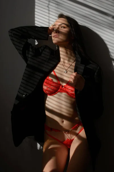 Giovane donna bruna in lingerie rossa in posa sotto il sole — Foto Stock