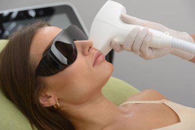 Kozmetoloji. Güzellik uzmanının elleri kaplıcada kadın yüzü için güzellik tedavisi yapıyor. Yüz tedavisi