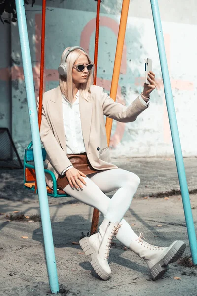 Young smiling cheerful woman outdoors using social media apps on phone for video chatting and stying connected. — Stock Photo, Image