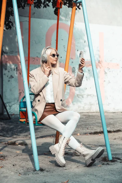 Joven sonriente mujer alegre al aire libre utilizando aplicaciones de redes sociales en el teléfono para el chat de vídeo y atascado conectado. — Foto de Stock