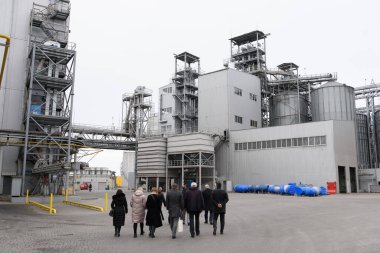 Sanayi bölgesi. Delegasyon fabrikanın etrafında dolaşıp kalkınma planını tartışıyor..