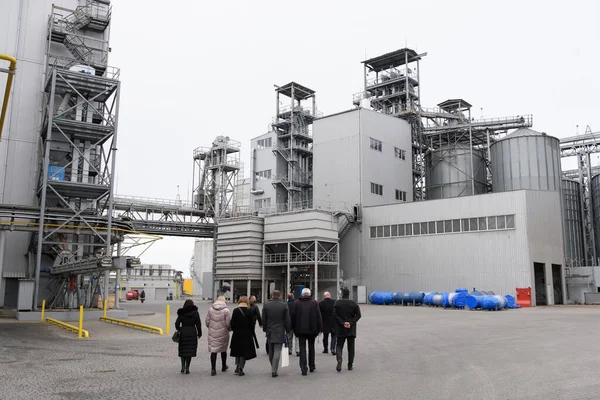 Sanayi bölgesi. Delegasyon fabrikanın etrafında dolaşıp kalkınma planını tartışıyor..