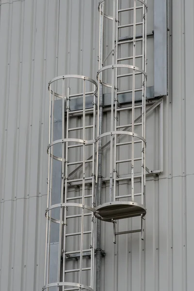 Escalera de hierro para trabajos de mantenimiento. Escaleras de acero están en el lado de las paredes del edificio —  Fotos de Stock
