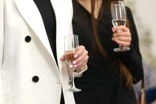 Luxurious woman wearing a white jacket, holding a glass with champagne — Fotografia de Stock