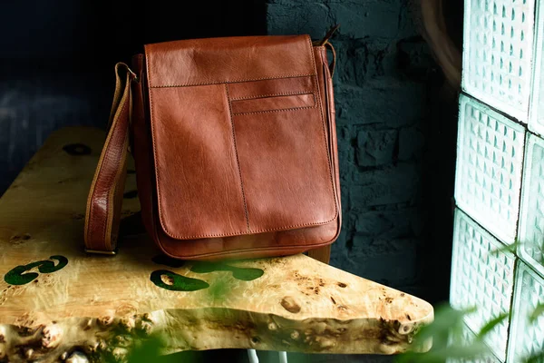 Close-up photo of orange leather messanger bag on a wooden table — Stock Photo, Image