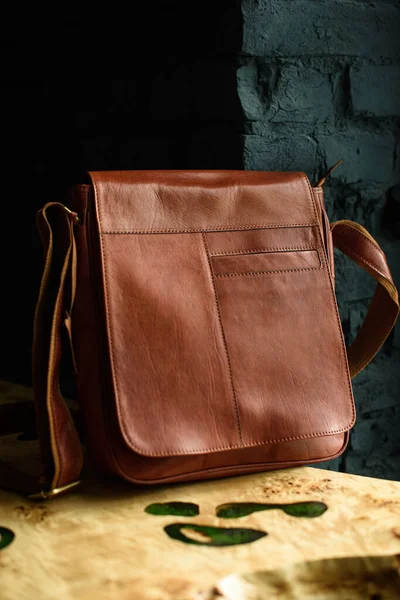 Close-up photo of orange leather messanger bag on a wooden table — Stock Photo, Image