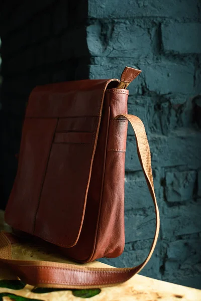 Close-up photo of orange leather messanger bag on a wooden table — Stock Photo, Image