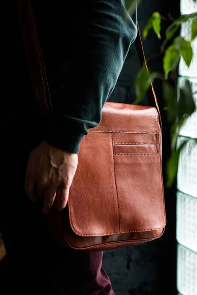 Close-up photo of orange leather bag on mans shoulder — Stock Photo, Image