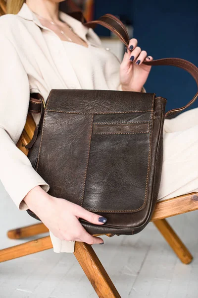 Close-up photo of brown messanger leather bag in womans hands — Stock Photo, Image
