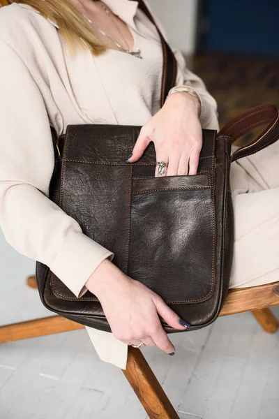 Close-up photo of brown messanger leather bag in womans hands — Stock Photo, Image