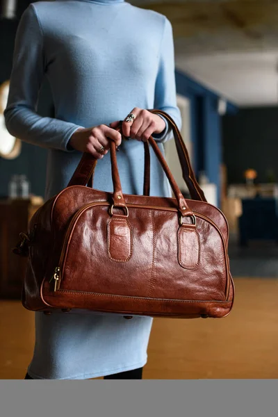 Close-up photo of orange leather travel bag in womans hands — Stock Photo, Image