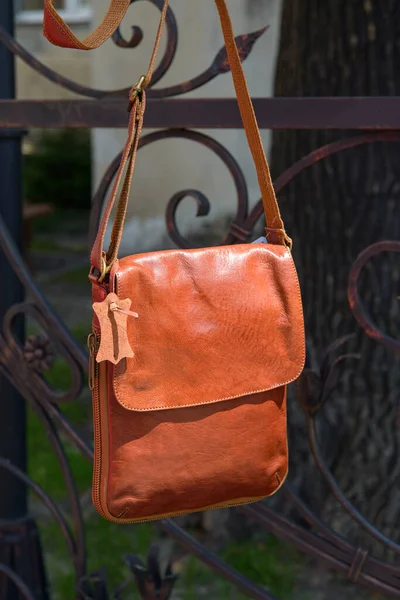 Outdoor photo of a orange leather Messenger bag. — Stock Photo, Image