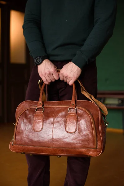 Close-up photo of orange leather travel bag in mans hands — Stock Photo, Image