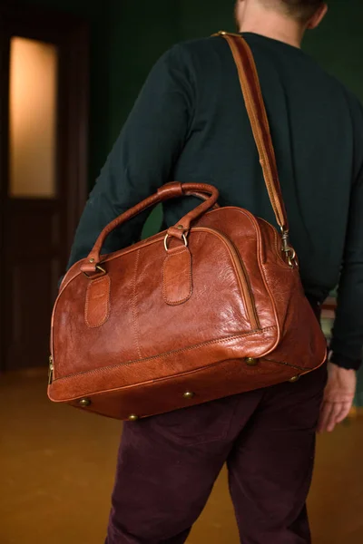 Close-up photo of orange leather travel bag on mans shoulder — Stock Photo, Image