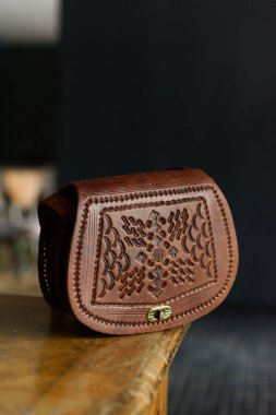 İşlenmiş desenli küçük kahverengi kadın deri çantası. seçici odak