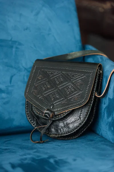 Small black womens leather bag with a carved pattern. Selective focus — Stock Photo, Image