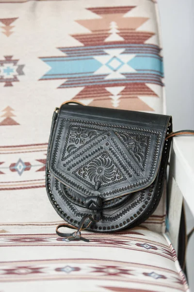 Small black womens leather bag with a carved pattern. selective focus — Stock Photo, Image