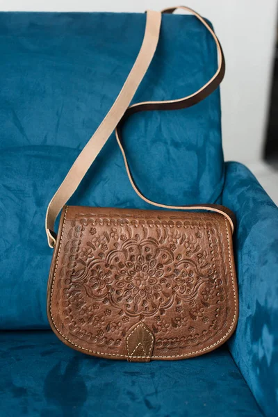 Μικρή καφέ γυναικεία δερμάτινη τσάντα με σκαλιστό σχέδιο. επιλεκτική εστίαση — Φωτογραφία Αρχείου