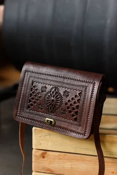 Small brown womens leather bag with a carved pattern. selective focus — Stock Photo, Image