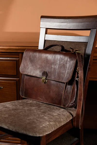 Коричневый кожаный портфель с антикварным и ретро выглядеть для человека на стуле. Фото номера в отеле — стоковое фото