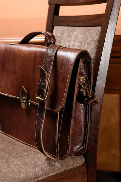 Brown leather briefcase with antique and retro look for man on a chair. Hotel room photo — Stock Photo, Image