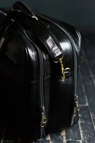 皮革黑色旅行袋，在黑色木制地板上 — 图库照片