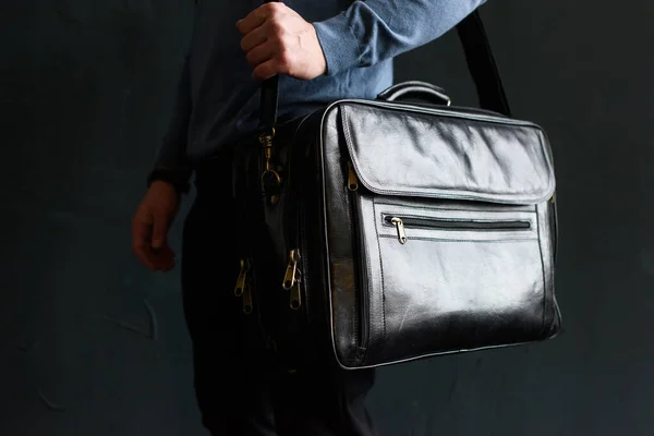 Man holding black leather travel bag. Soft light — Stock Photo, Image