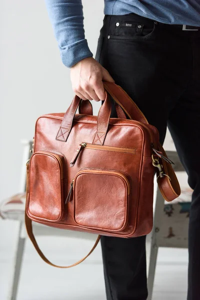 Side view of man in a blue sweater with red leather briefcase. Retro style. Unisex bag for sale. — Stock Photo, Image
