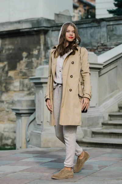 Portrait de femmes à la mode en costume de sport beige, trench coat et élégant mocassin en daim posant sur les escaliers en pierre — Photo