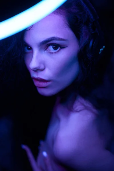Emozionale ritratto in studio di una giovane donna in cuffia wireless con effetto ring flash. Lampada rotonda del cerchio del LED. — Foto Stock