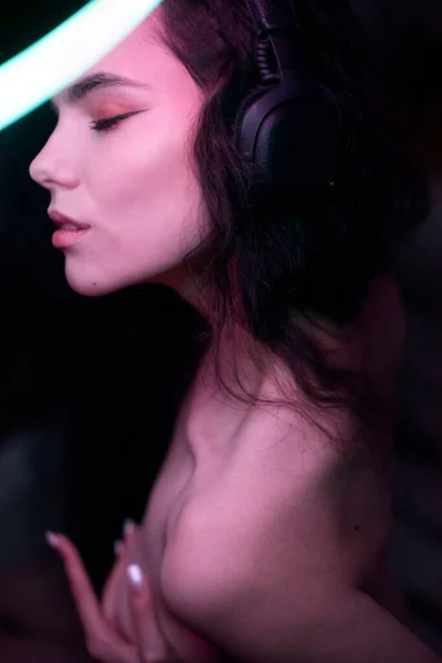 Kablosuz kulaklıklı, halka efektli genç bir kadının duygusal stüdyo portresi. Yuvarlak LED Çember Lamba. — Stok fotoğraf