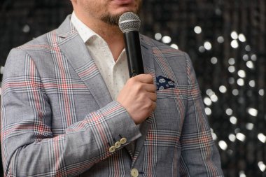 İş ve konuşma konusu: siyah mikrofon tutan kareli ceketli adam. Yatay fotoğraf