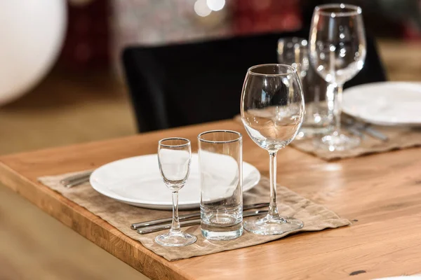 Скляний посуд на дерев'яному столі. чистий і порожній. затишна атмосфера. обслуговування бенкету — стокове фото