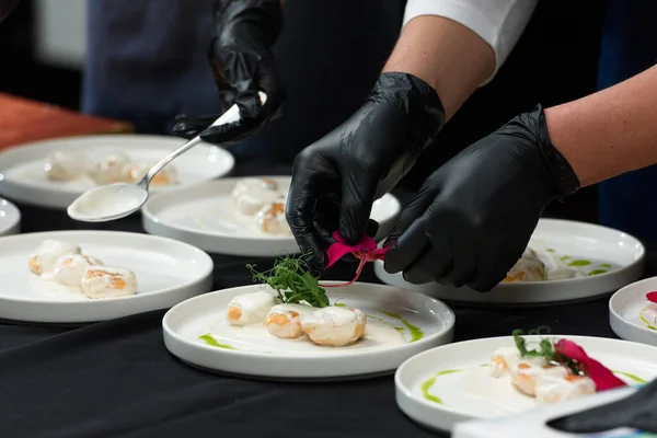 the chef prepares a dish of fish balls in a creamy sauce