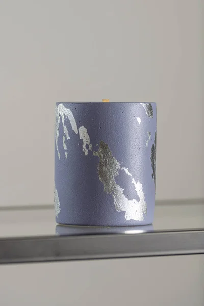 Στρογγυλό κηροπήγιο με αφηρημένες μουτζούρες, μπλε σκυρόδεμα με ασημένια φλόγα. επιλεκτική μαλακή εστίαση — Φωτογραφία Αρχείου