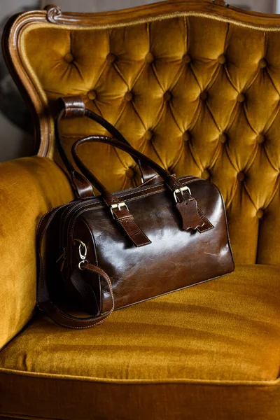 Close-up photo of brown leather bag on a vintage sofa — Stock Photo, Image