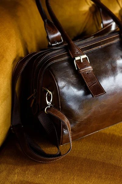 Крупным планом фото коричневой кожаной сумки на винтажном диване — стоковое фото