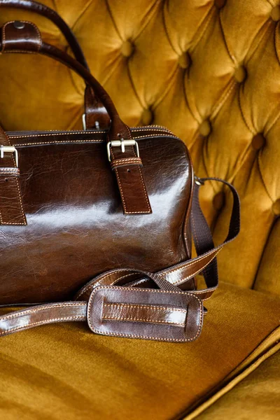 Close-up photo of brown leather bag on a vintage sofa — Stock Photo, Image