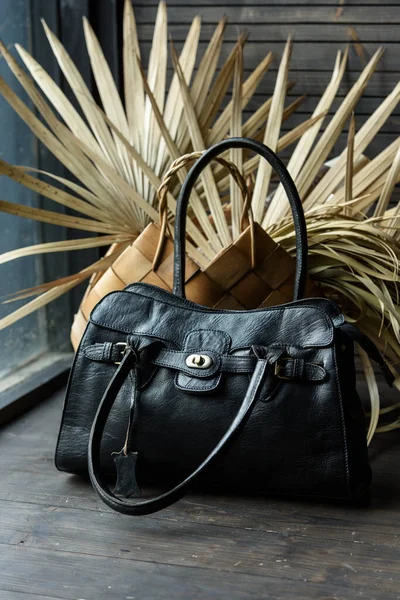 Close-up photo of black leather bag on a wooden table — Stock Photo, Image