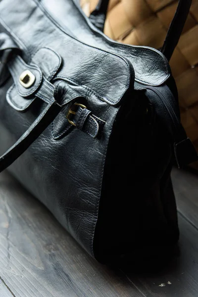 Close-up photo of black leather bag on a wooden table — Stock Photo, Image