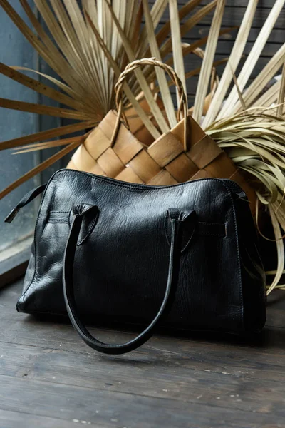 Close-up photo of black leather bag on a wooden table — Stock Photo, Image