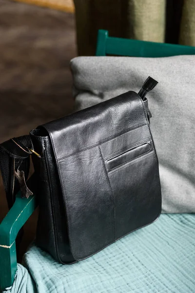 Close-up photo of black messanger leather bag on a chair — Stock Photo, Image