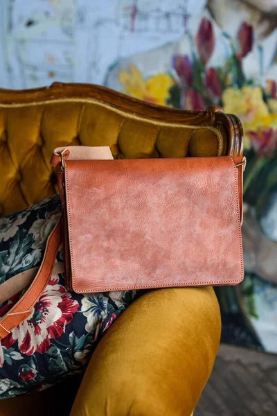 Close-up photo of orange leather bag on a vintage sofa — Stock Photo, Image