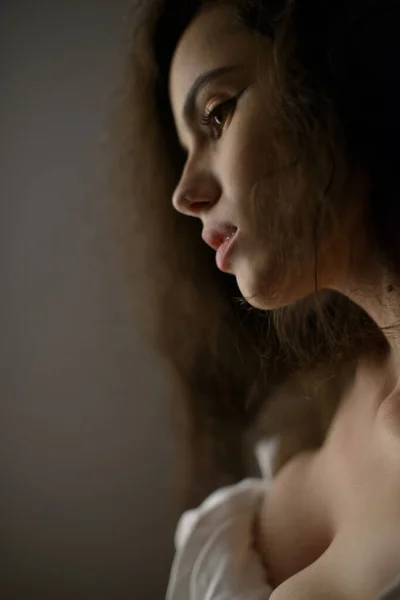 Portret seksownej młodej kobiety z bardzo długimi kręconymi włosami kusząco pozowanie w studio — Zdjęcie stockowe