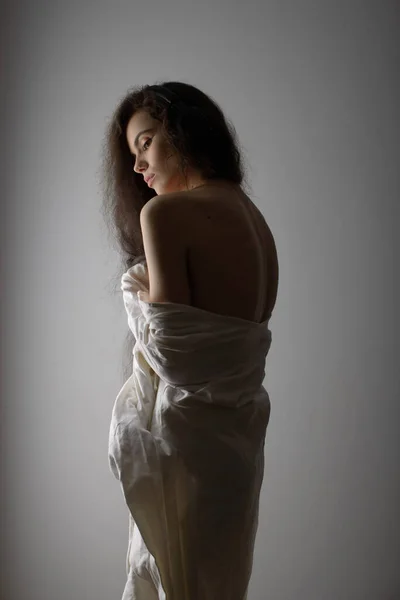 Портрет сексуальної молодої жінки з дуже довгим кучерявим волоссям спокусливо позує в студії — стокове фото