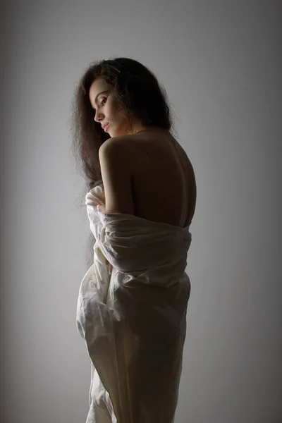 Portrait of sexy young woman with very long curly hair seductively posing in studio — Stock Photo, Image